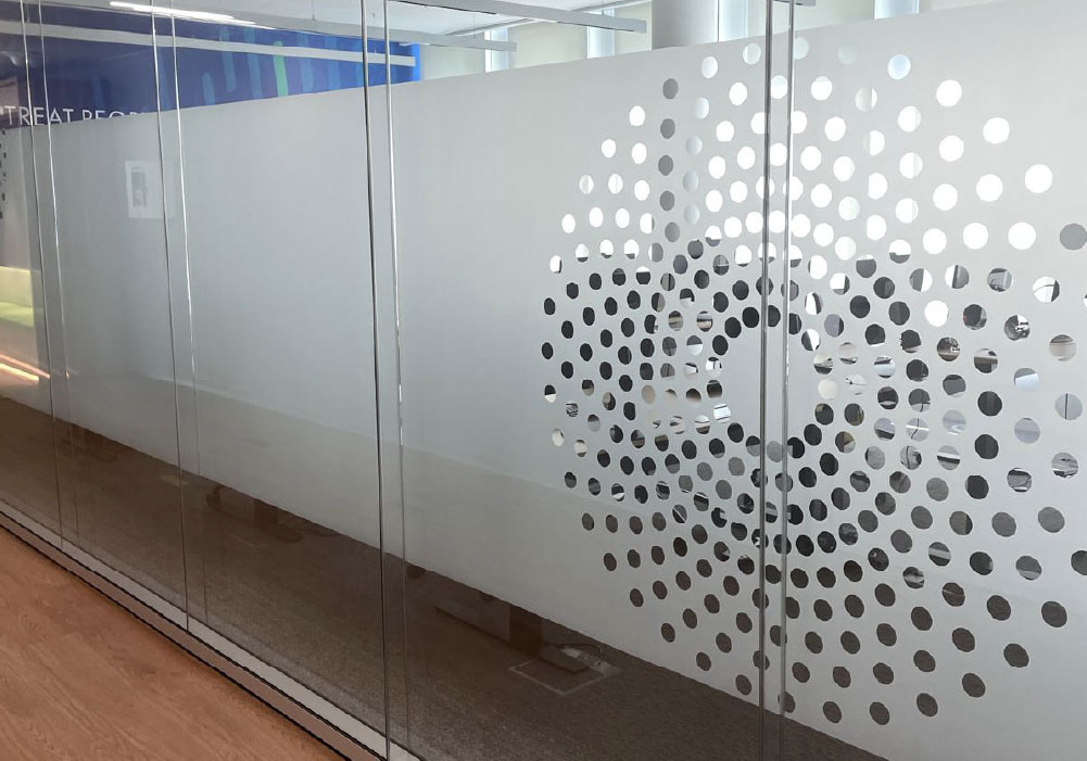 Konturgeschnittene Milchglasfolie mit Kreismotiven auf einer Glaswand im Büro-Besprechungsraum